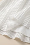 Plisseekleid Rozalia in Weiß – Plisseefalten am Saum und glattes Futter – Detailaufnahme